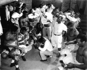 Coach_Jake_Gaither_(standing,_middle,_white_shirt)_in_the_locker_room_with_his_Florida_Agricultural_and_Mechanical_University_(FAMU)_football_team